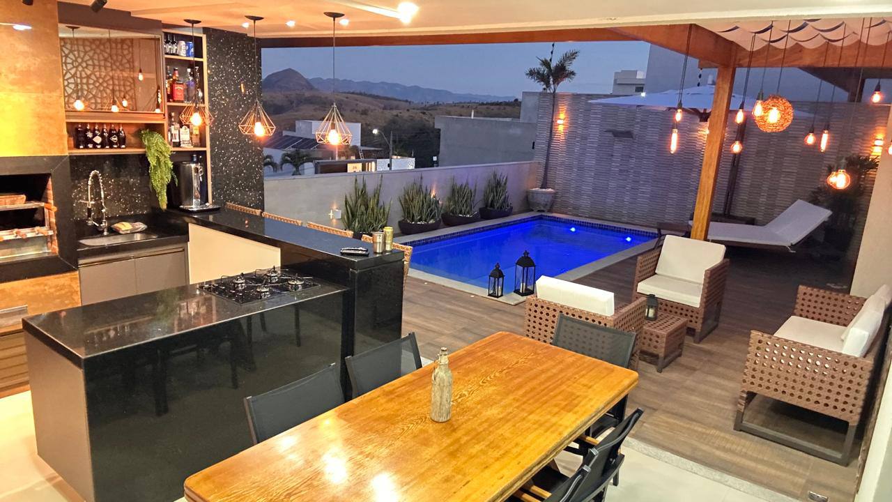 Área gourmet ao entardecer com piscina iluminada